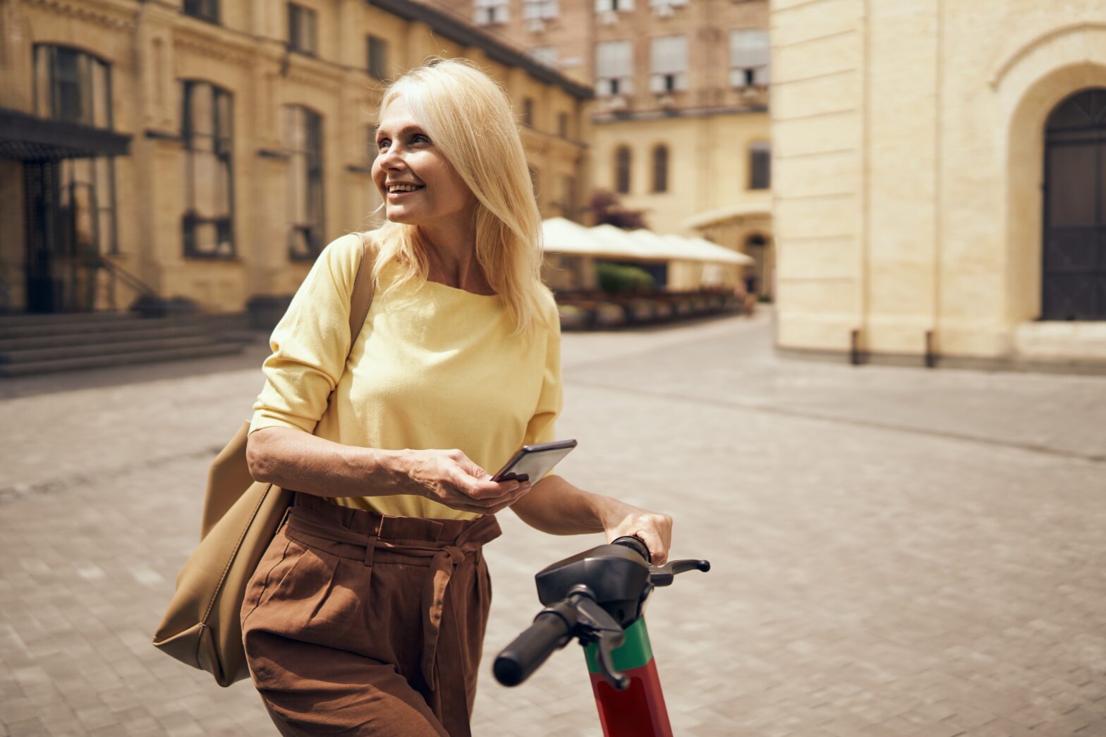 A woman on her phone exploring on a scooter