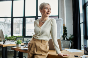 An empowered woman standing in a wealth management office smiling and looking out the window