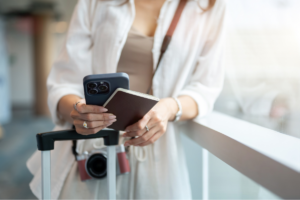 Woman holding her phone and passport at the airport.